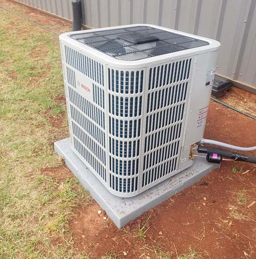 HVAC service technician working on heating and cooling equipment in Harvest Alabama